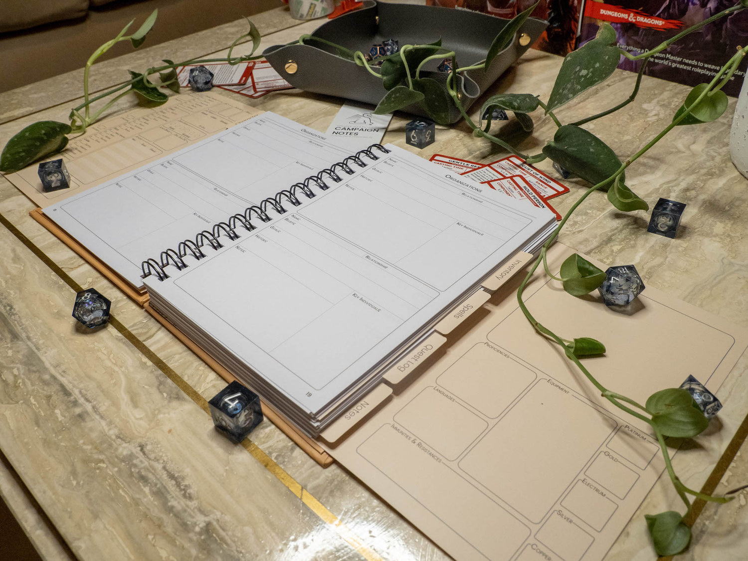 open Dungeons and Dragons Fifth edition 5e notebook surrounded by DND accessories from and angled view
